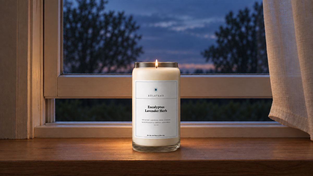 Solstead Eucalyptus Lavender Herb soy candle, lit on a windowsill at dusk
