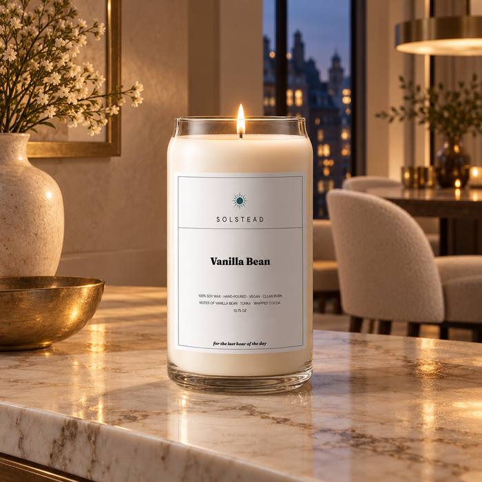 Solstead Vanilla Bean 13.75 oz soy candle burning on a marble table in an evening dining room