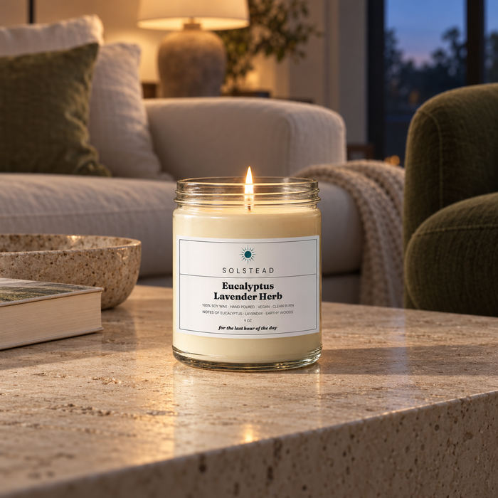 Solstead Eucalyptus Lavender Herb 9 oz soy candle burning on a stone side table in a living room at sunset