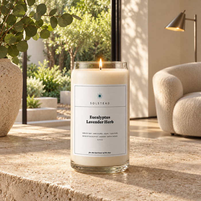 Solstead Eucalyptus Lavender Herb 13.75 oz soy candle burning on a stone table in a bright room with a garden view
