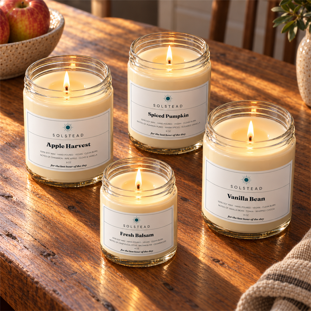The Harvest Set by Solstead seen from above, the four candles glowing on a wooden table in afternoon light